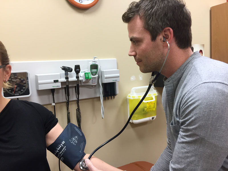 Nurse checking blood pressure of patient